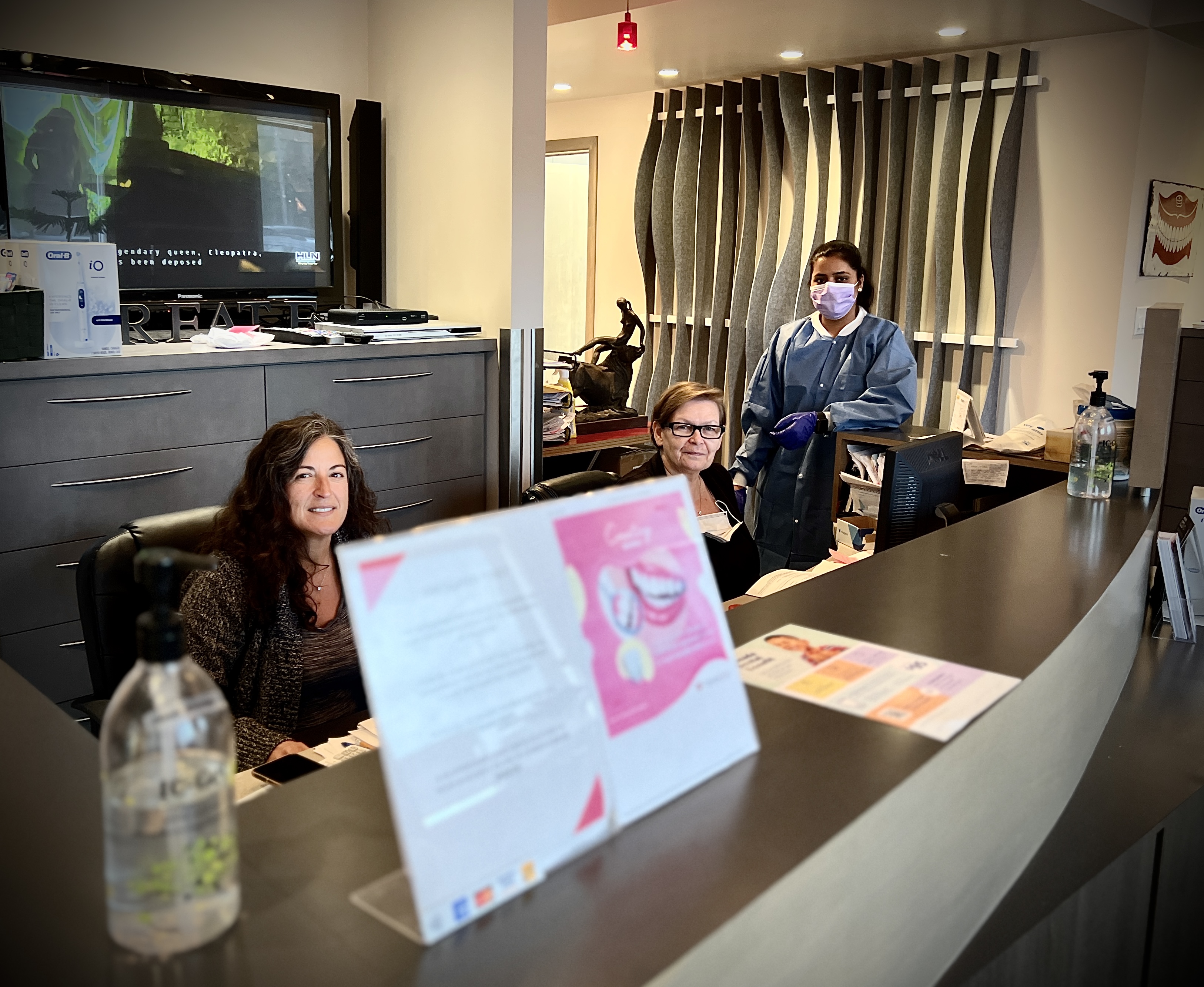 A picture of several friendly receptionists and a dental assistant